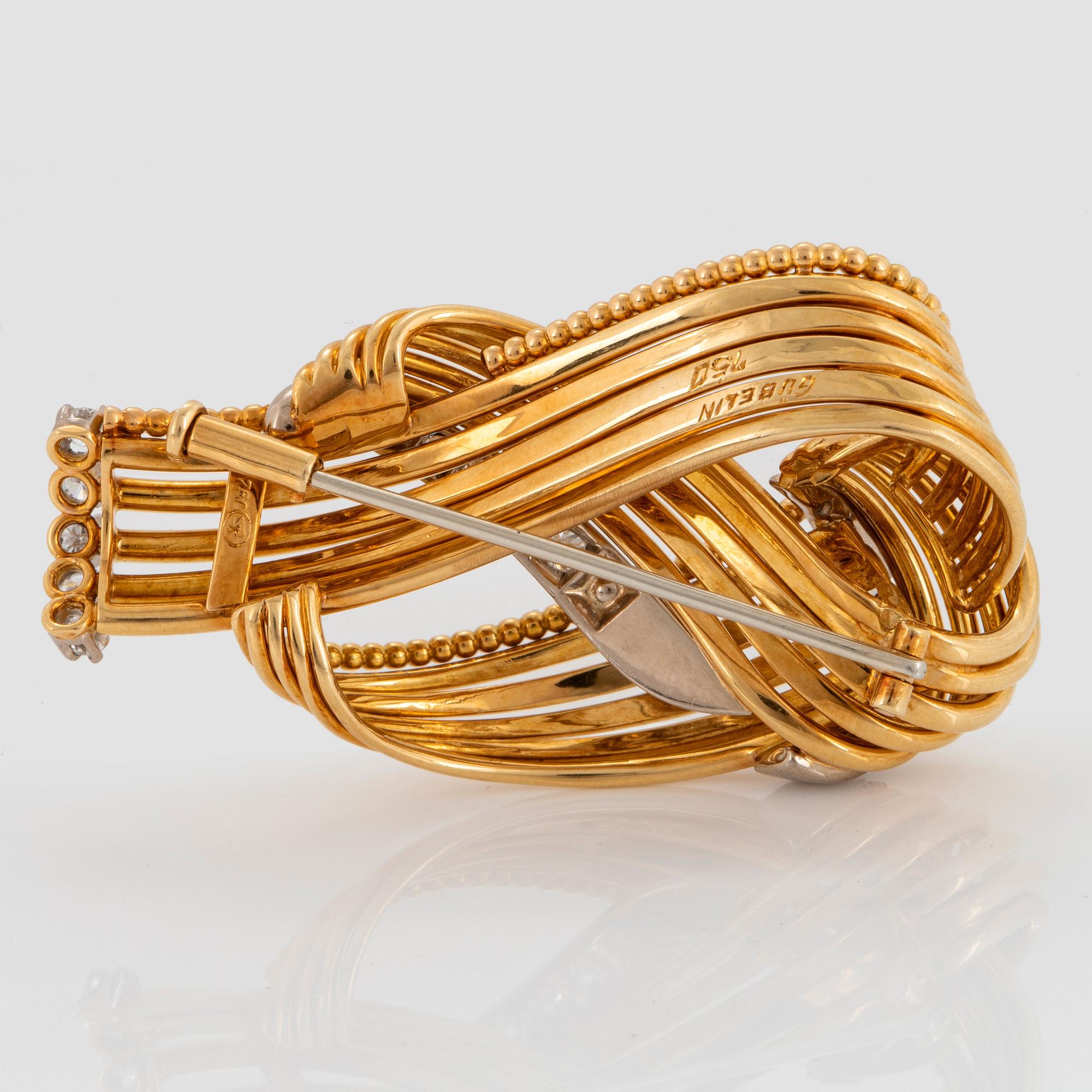 A Gübelin brooch in 18K gold set with round brilliant-cut diamonds.