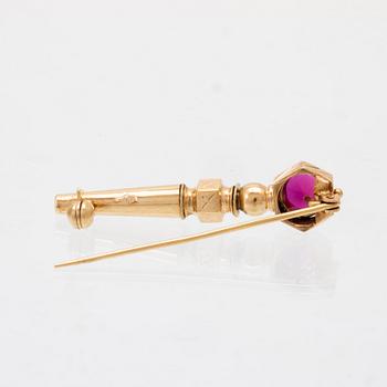 An 18K gold brooch set with a synthetic ruby.