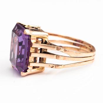 A 9-14K gold ring with a synthetic sapphire.