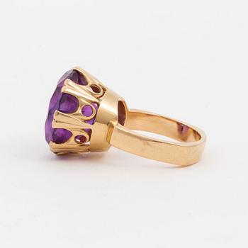 A ring set with a synthetic, purple sapphire.
