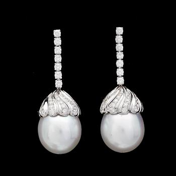 121. A pair of cultured South sea pearl, 14,4 mm, and brilliant cut diamond earrings, tot, app. 1.45 cts.