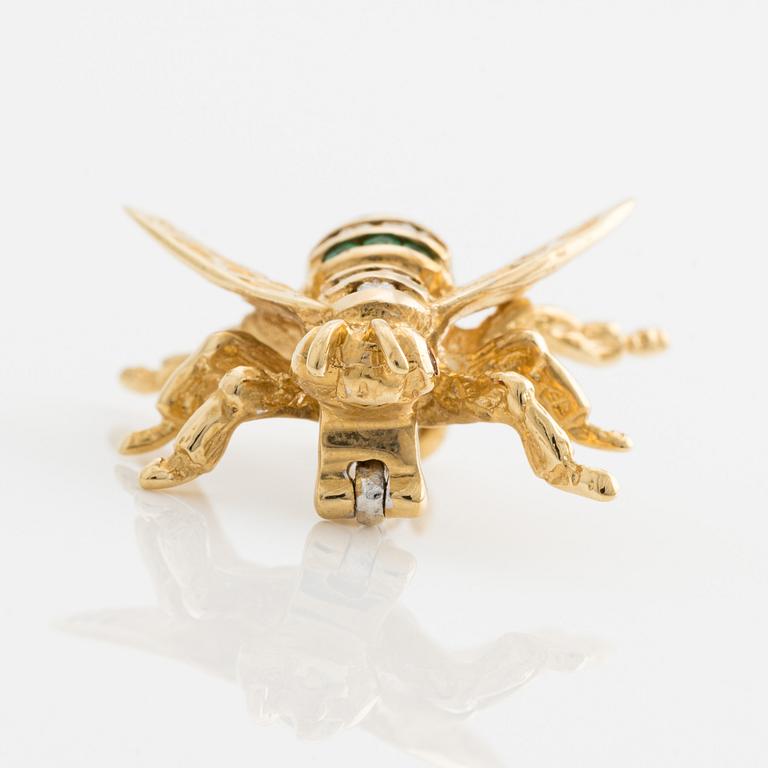 Brooch 18K gold set with round faceted emeralds and rubies, as well as round brilliant-cut diamonds.