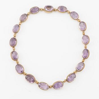 A set with a necklace, a bracelet, a brooch, and a ring.