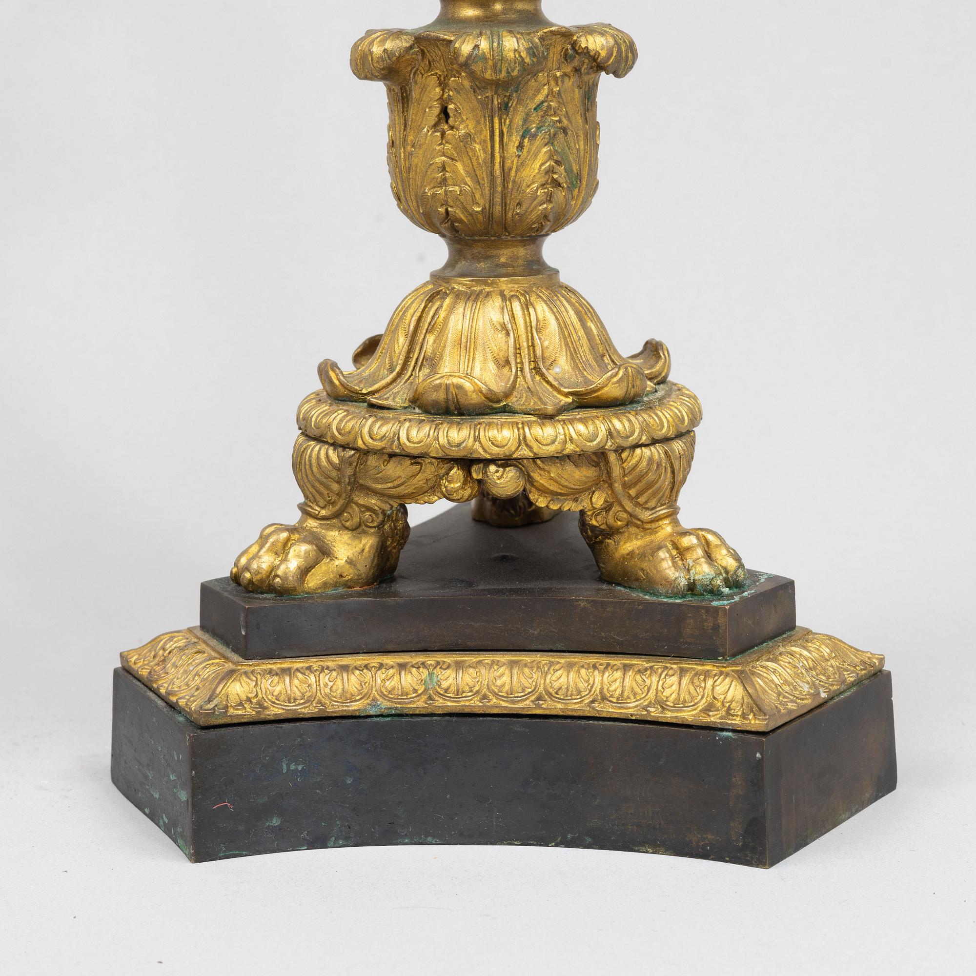 A pair of French Empire-style patinated and gilt bronze five-light candelabra, later part 19th century.