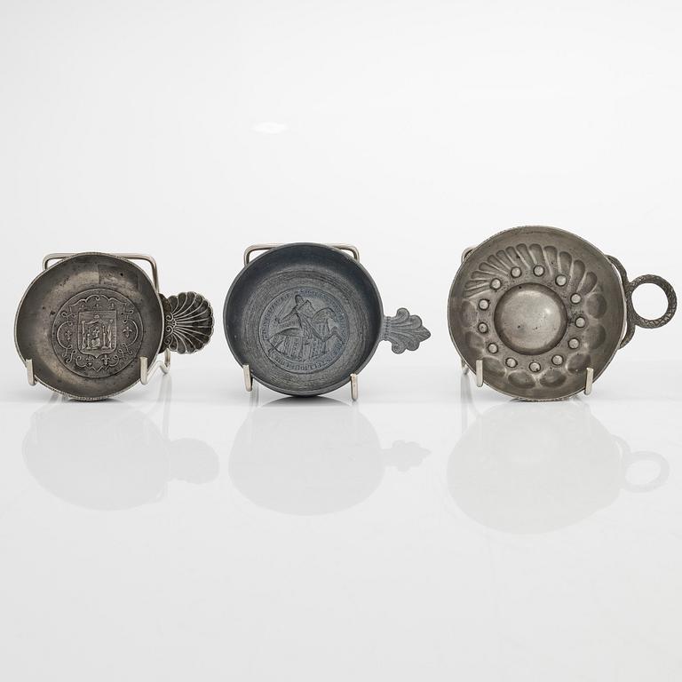 A set of fourteen tastevin cups, pewter and glass, 20th century.