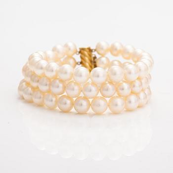 A three-strand pearl bracelet with cultured pearls and a 14K gold clasp.