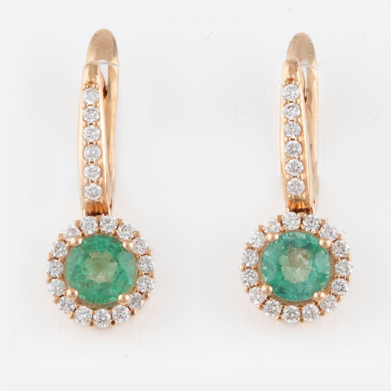 A pair of earrings with faceted emeralds and round brilliant-cut diamonds.