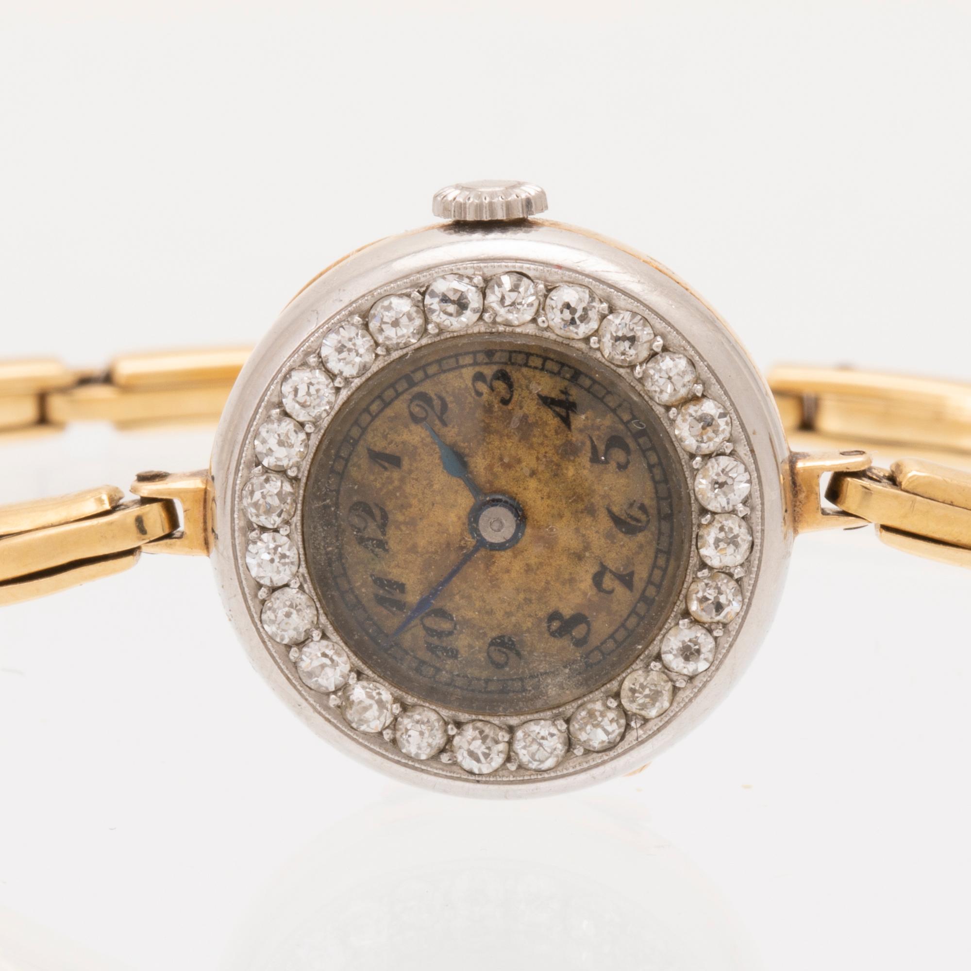 An 18K white and red gold watch set with round old cut diamonds.
