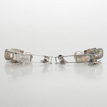 Four shakers in a pair of miniature rickshaws, sterling silver, maker's mark of Wai Kee, Hong Kong.