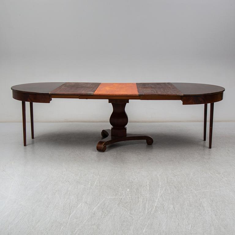 a mid 1800's mahogany dining table with three leaves.