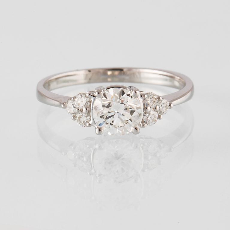 RING, 18K vitguld med en briljantslipad diamant 0.71 ct samt små briljantslipade diamanter 0.18 ct. Vikt 2,3 gram.