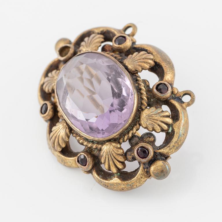 Brooch, gilded metal with a faceted amethyst.