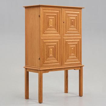 A Swedish Modern oak cabinet on stand attributed to Oscar Nilsson, 1940's.