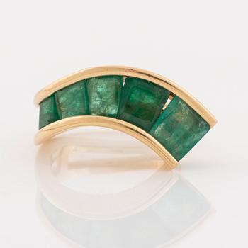 An 18K gold Lantz ring set with step-cut emeralds.