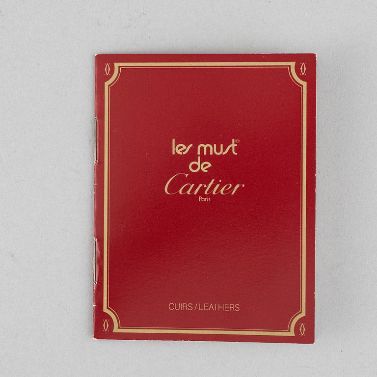 Cartier, a red suede clutch.