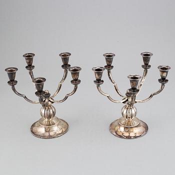 A pair of Swedish Grace silver candelbar for        five candles, mark of GAB, Stockholm, 1929.