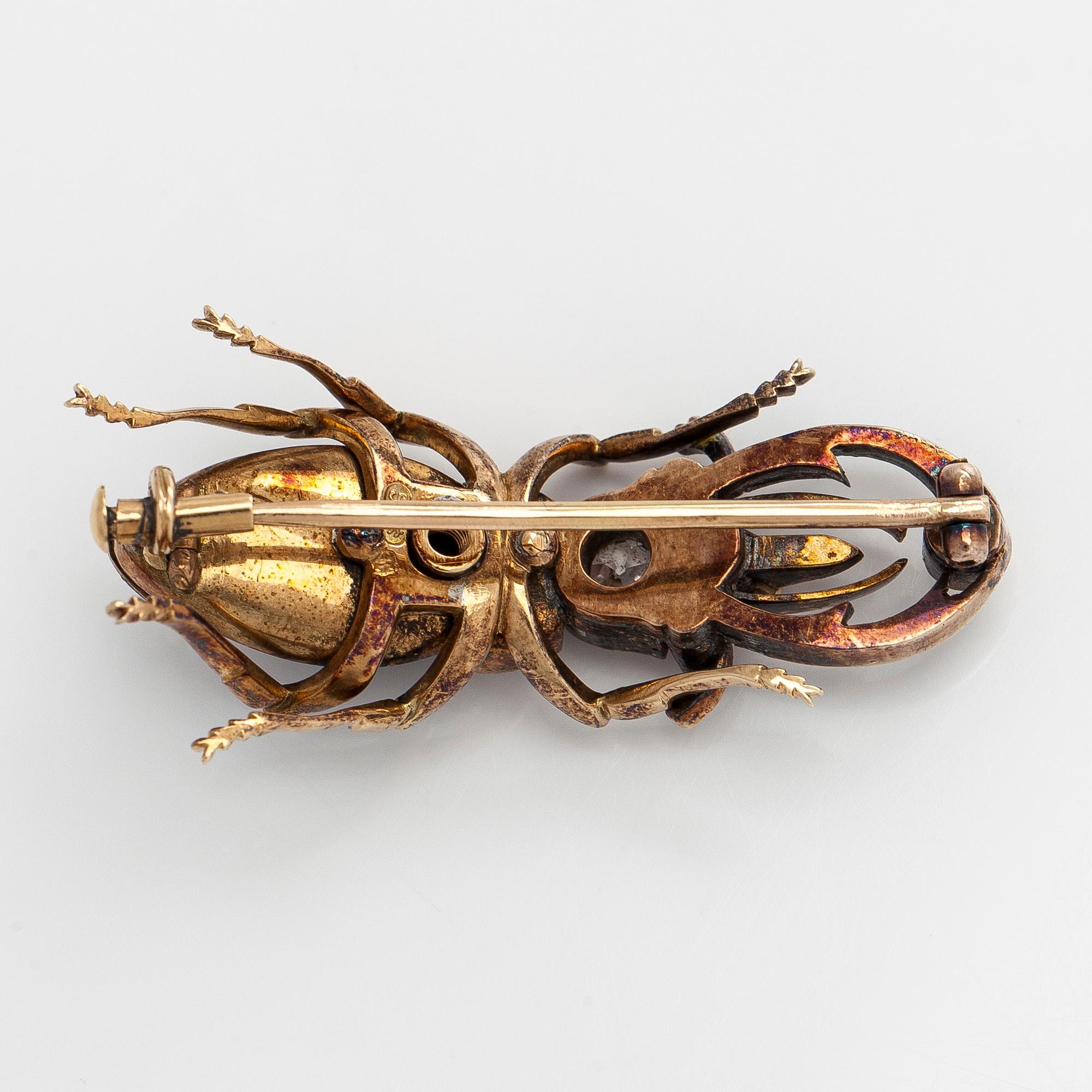 A 14K gold brooch with tiger’s eye, old-cut and rose-cut diamonds, ruby, emeralds. St. Petersburg.