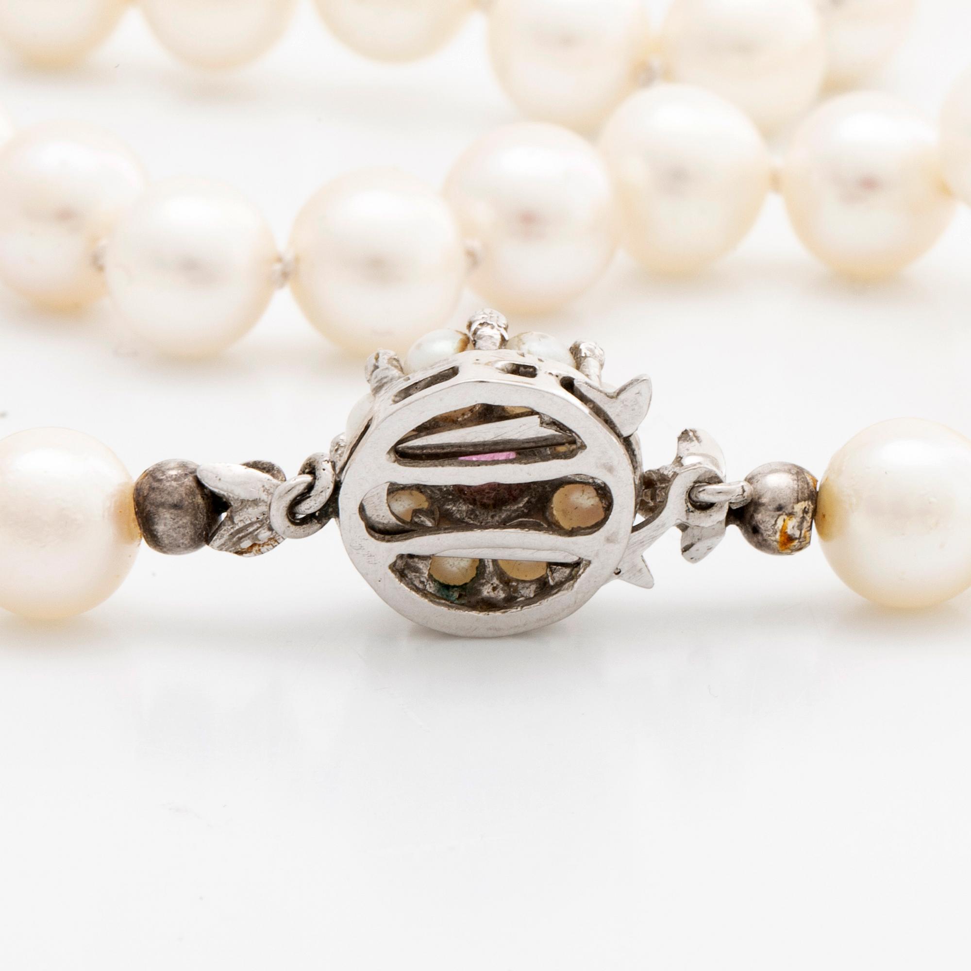 PEARL NECKLACE, cultured pearls approx 7 mm, clasp 18k whitegold cultured pearls and 1 ruby, approx length 93 cm.