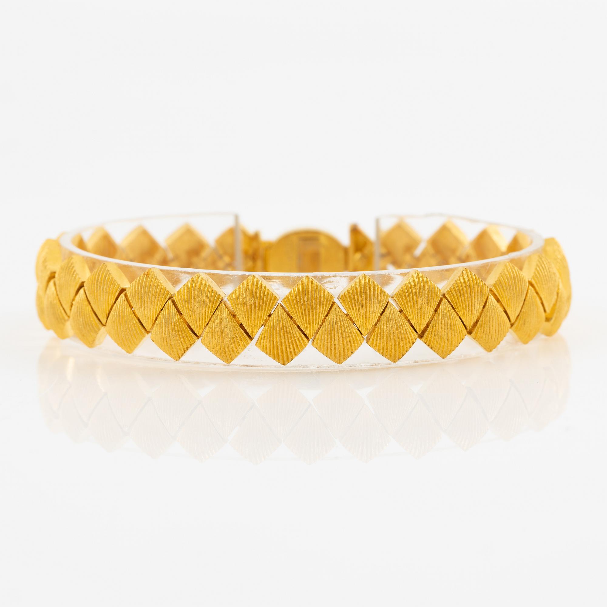 Garnityr av guldsmycken, en collier (14K), ett armband (18K), ett par örhängen (14K) och en ring (14K).