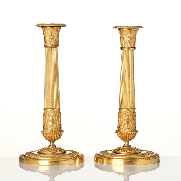 A pair of French Empire ormolu candlesticks, early 19th century.