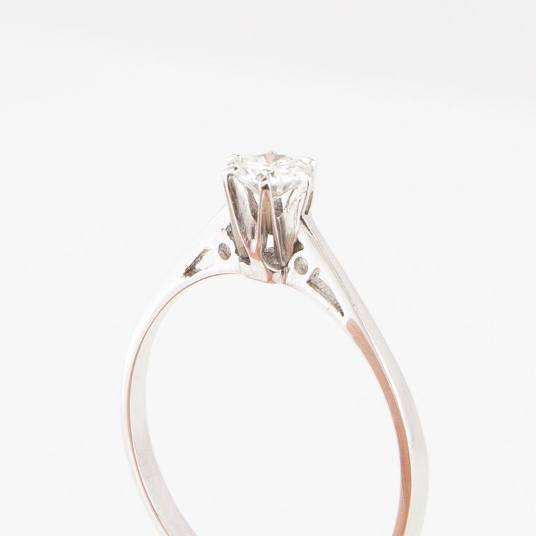 An 18K white gold solitaire ring set with a round brilliant-cut diamond.