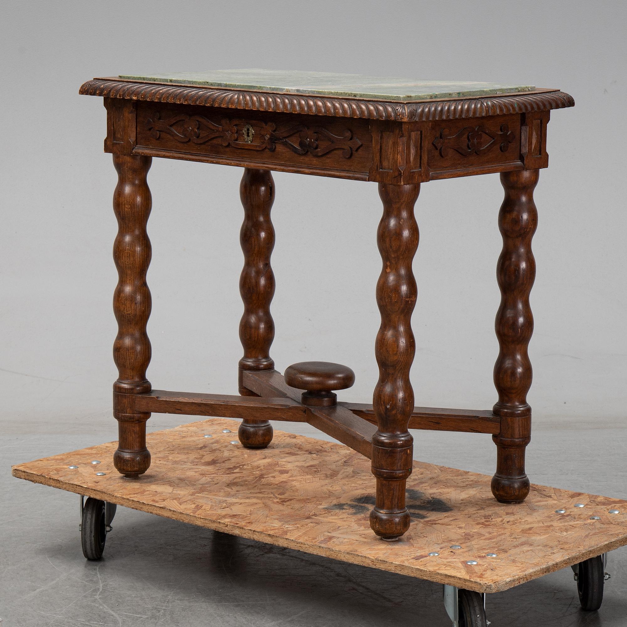 An early 20th Century oak side table with a stone top.