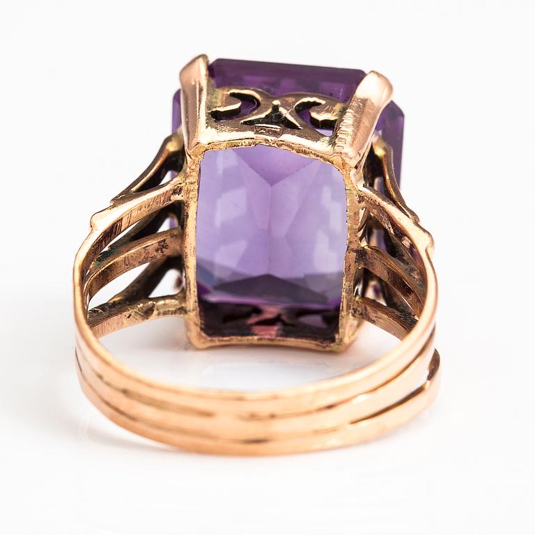 A 9-14K gold ring with a synthetic sapphire.