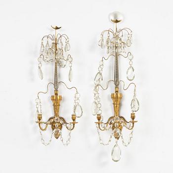 A pair of Gustavian-style ormolu two-light wall candleholders, 19th Century.