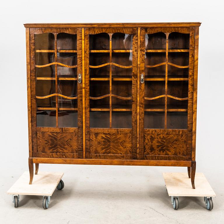 A glass and veneered cabinet from the first half of the 20th century.