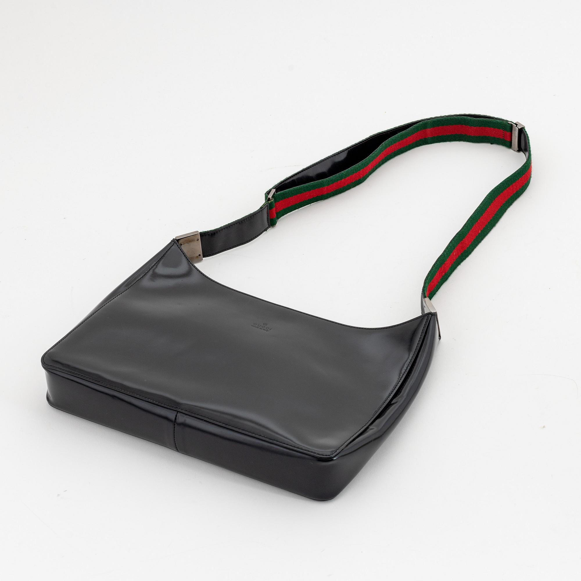 Gucci, a black, patent leather handbag.