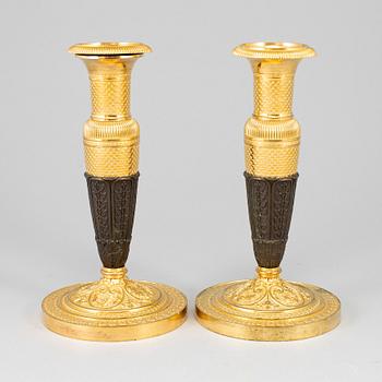 A pair of empire, ormolu candlesticks, first half of the 19th century.