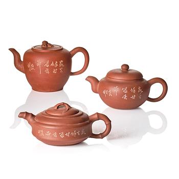1186. A group of three Chinese yixing tea pots with cover.