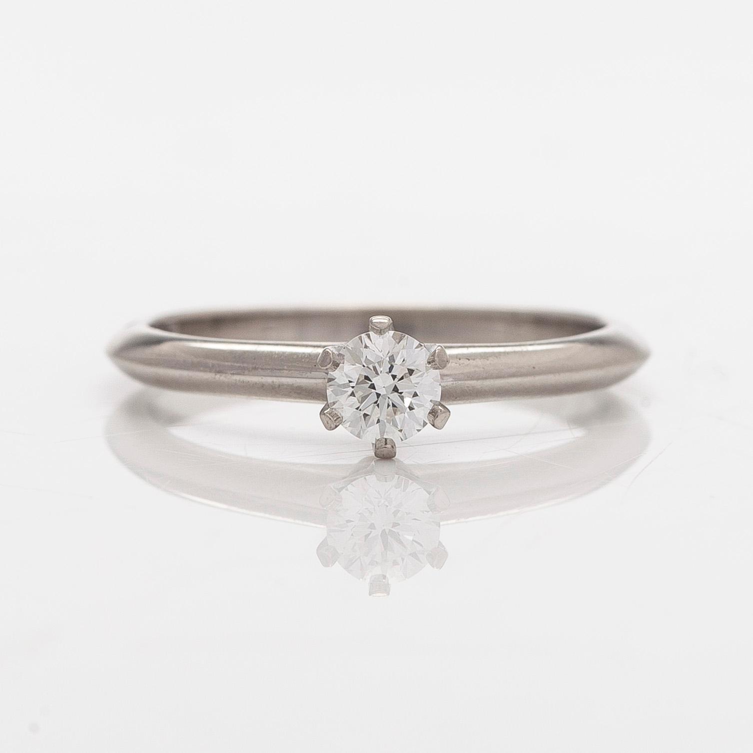 Tiffany & Co, sormus, platinaa, briljanttihiottu timantti n. 0.23 ct kaiverruksen mukaan. Sertifikaatilla.