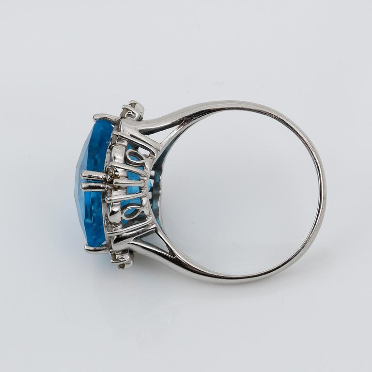 RING, 14K vitguld med blå checkerslipad topas tot ca 2.77 ct omges av små åttkantslipade diamanter. Vikt 4.56 g.