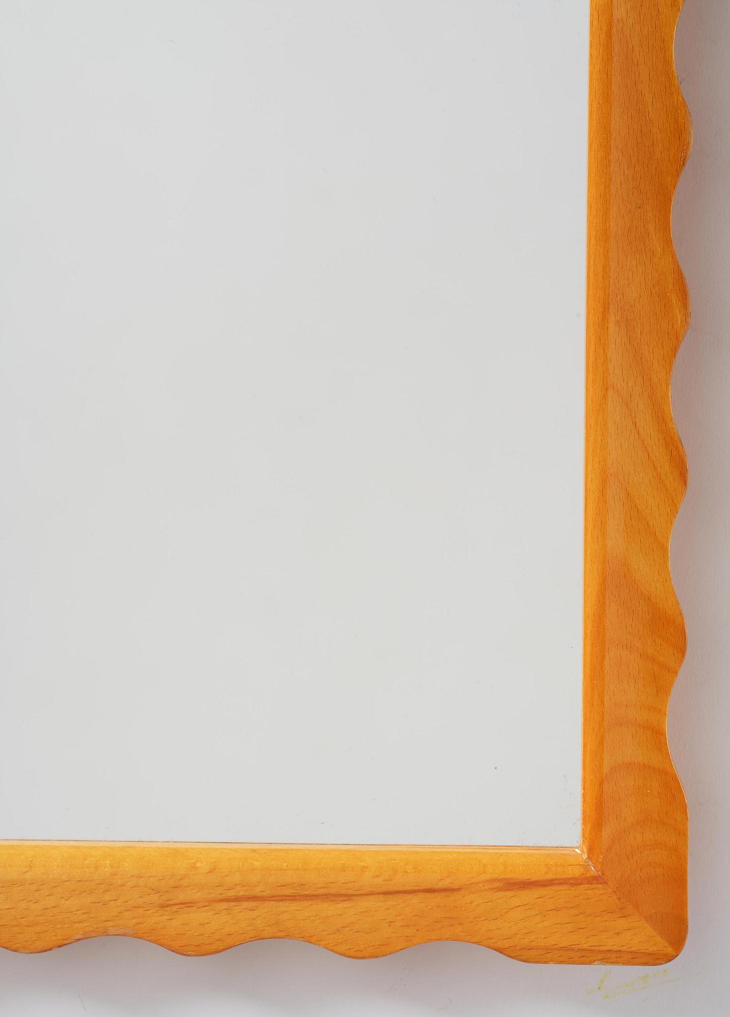 Swedish Modern, a wall mirror with wave-shaped frame, 1940s.