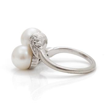 A cross-over ring of two cultured pearls with eight-cut diamonds.