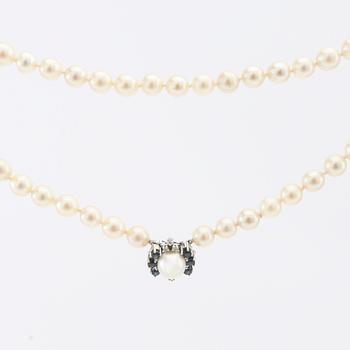 Necklace of cultured pearls with an 18K white gold clasp and round single-cut diamonds and round faceted sapphires.