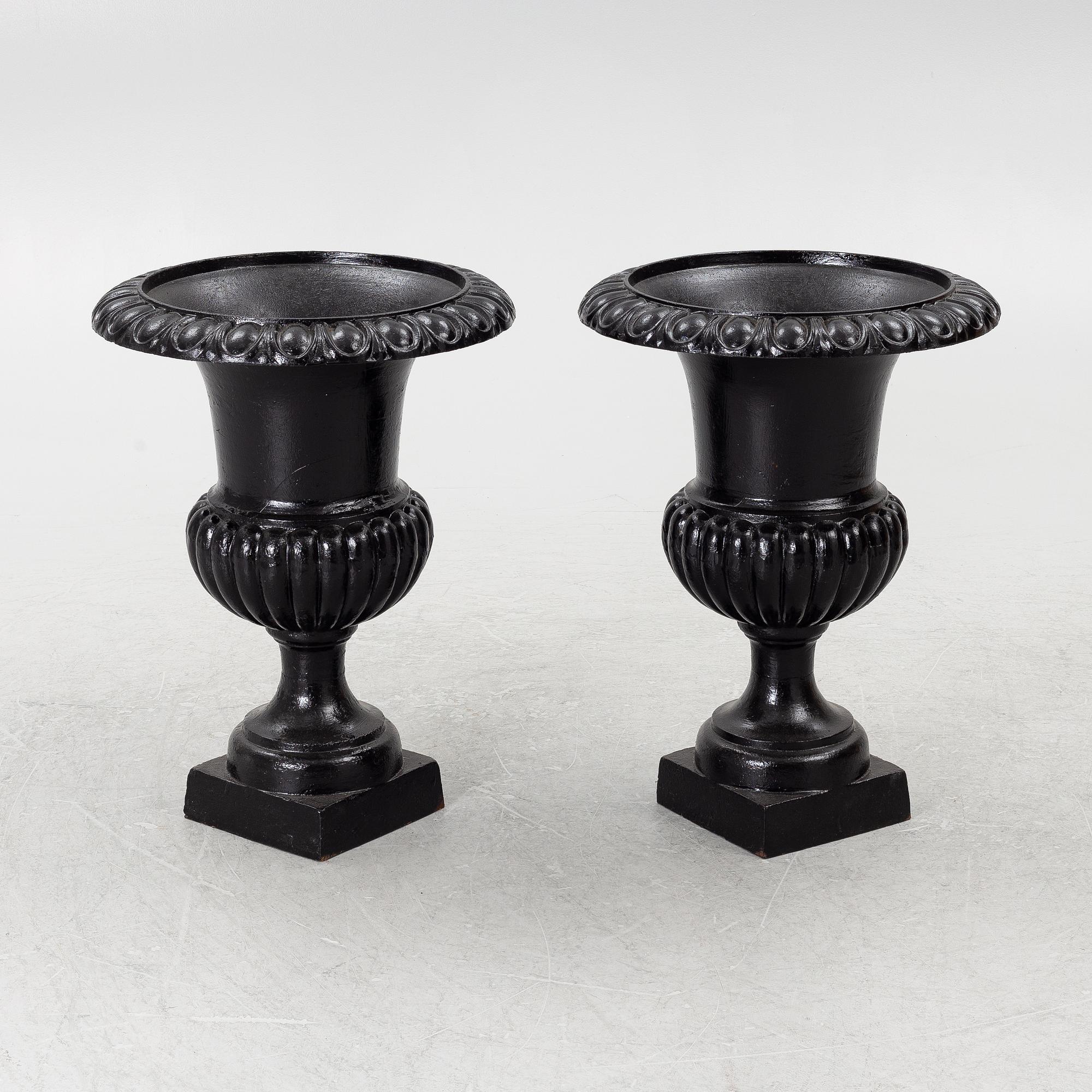 A pair of cast iron garden urns, 20th century.