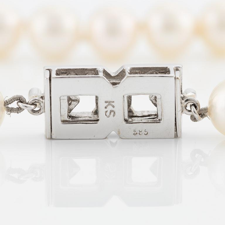Pearl necklace, longer model, cultured pearls, clasp in 14K white gold with baguette and brilliant-cut diamonds.