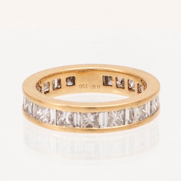 An 18K gold eternity ring set with baguette and princess cut diamonds by Hartmann's Denmark.
