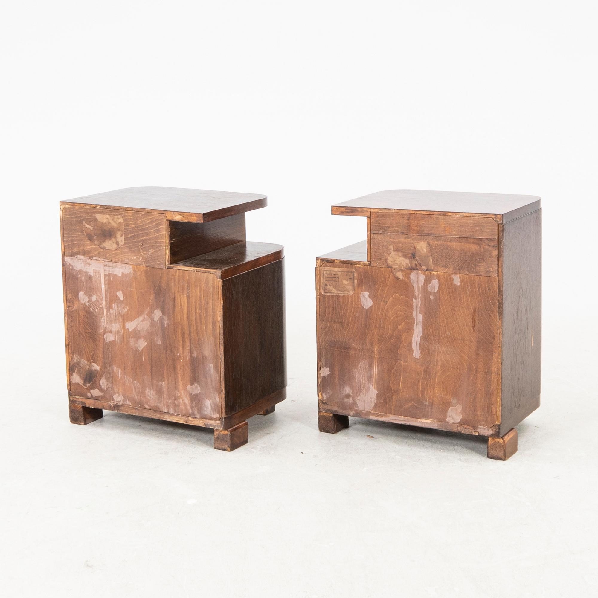 A pair of stained wood bedside tables from the first half of the 20th century.