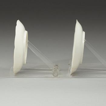 A pair of white-glazed small moulded dishes, Qing dynasty, Yongzheng six-character mark and of the period.