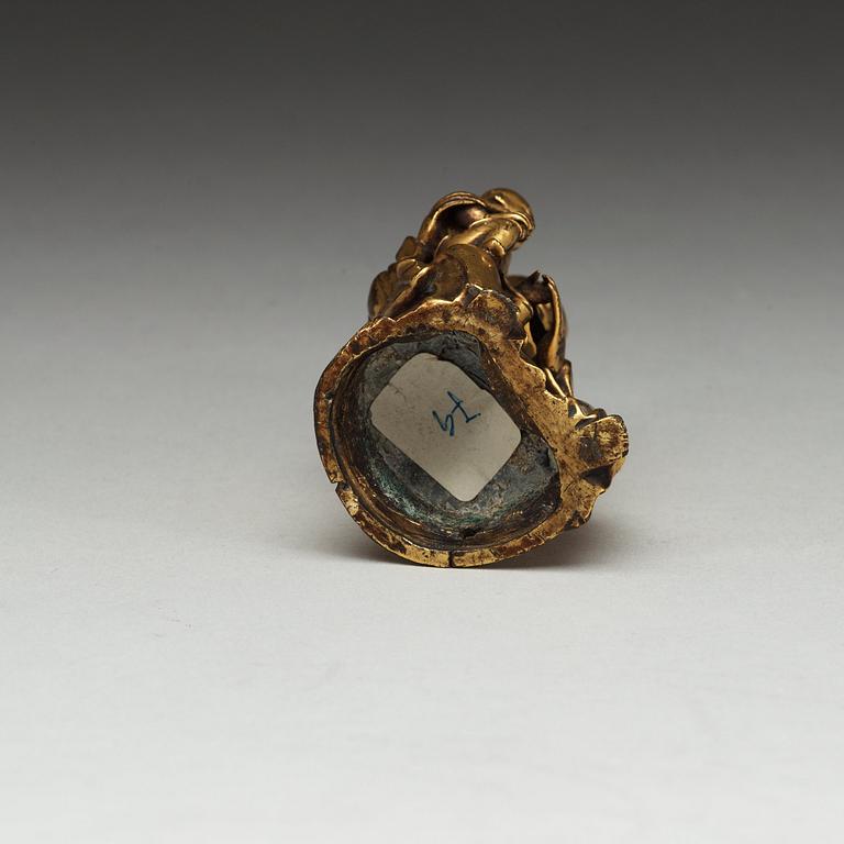 A seated gilt bronze figure of Guanyin with a small boy, Qing dynasty, 18th Century.