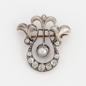 A brooch set with a mabé pearl and old-cut diamonds.