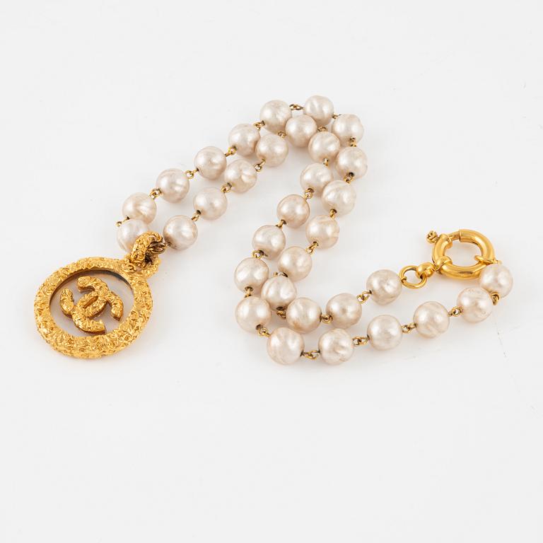 Chanel, A imitation pearl necklace with gold plated CC-charm, 1993.