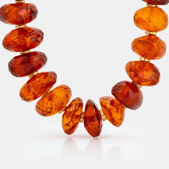 An amber necklace comprising graduated faceted amber beads ca 40 - 50 mm.