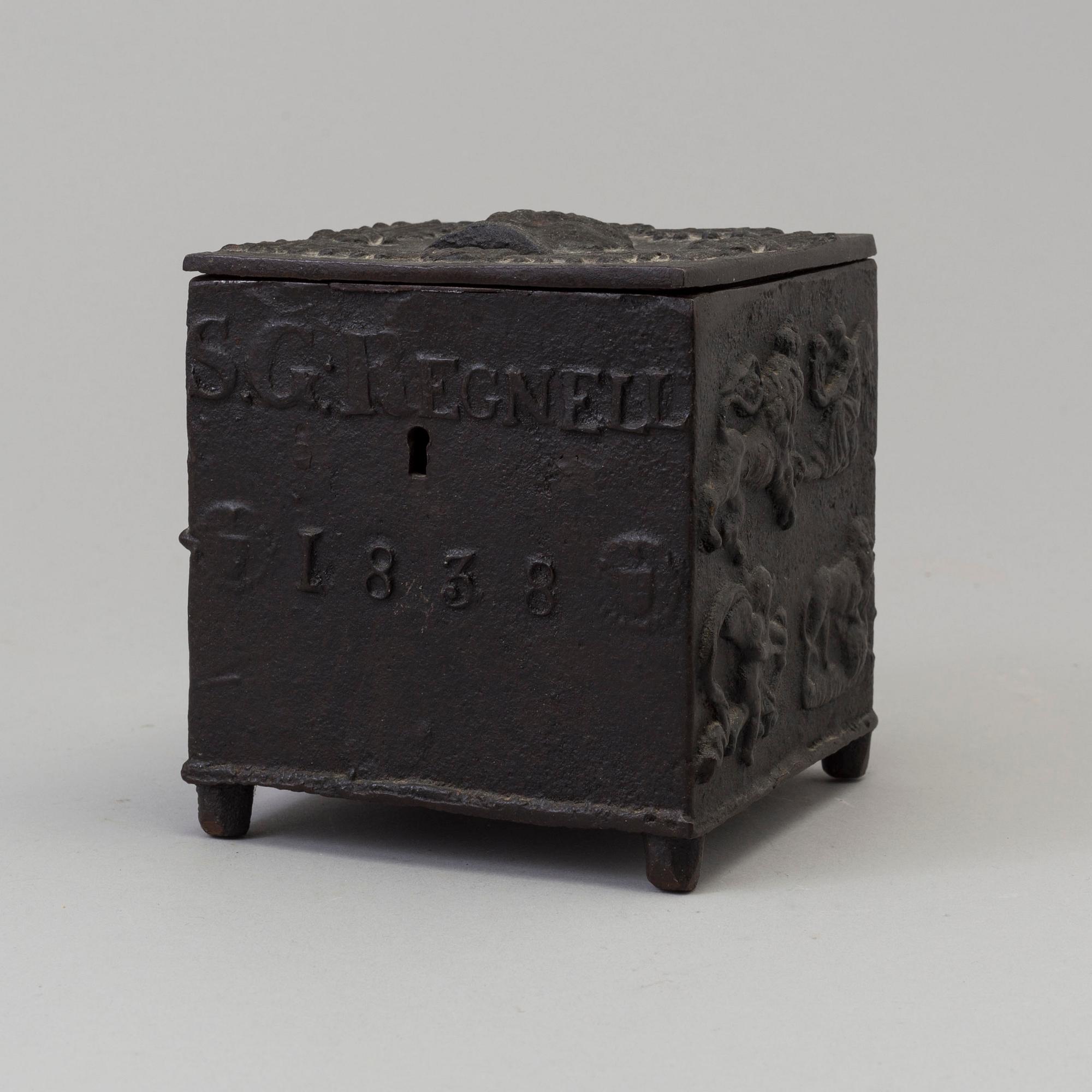 An empire cast iron tobacco box, dated 1838.