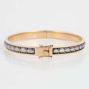 An 18K gold bangle.