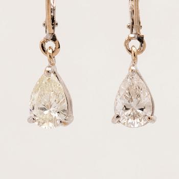 A pair of 18K white gold earrings set with pear cut diamonds.