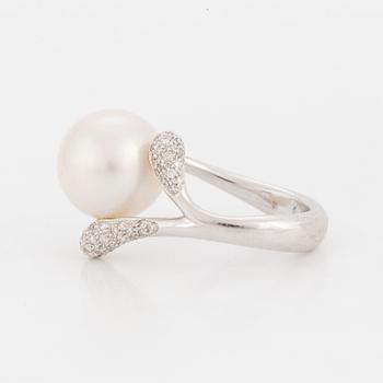 A ring set with a cultured 'South Sea' pearl and round, brilliant-cut diamonds.